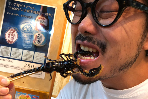 サソリ串を食べる